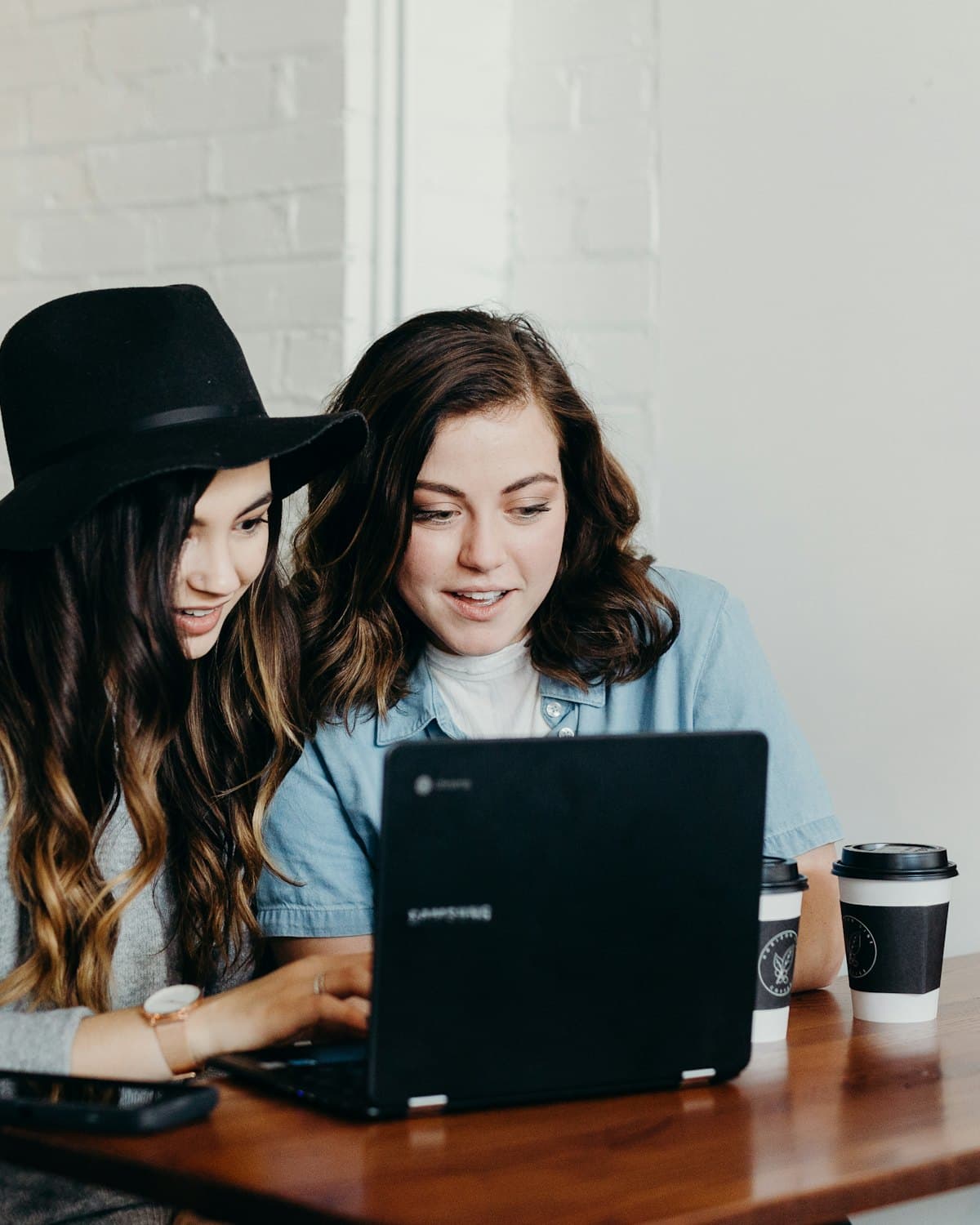 Two small-business owners building a system together at a laptop
